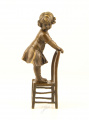 Bronze statues of a little girl in a dress on a stool