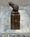 Bronze statue of a cat on a marble plinth