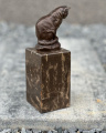 Bronze statue of a cat on a marble plinth