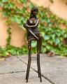 Bronze naked woman on a bar stool
