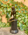 Seductive sitting naked woman made of bronze