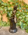 Seductive sitting naked woman made of bronze