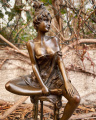 Statue of a woman on chair made of bronze