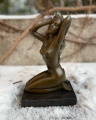 Statue of a nude sitting girl made of bronze