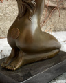 Statue of a nude sitting girl made of bronze
