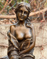 Statue of a girl with apple on bar chair made of bronze