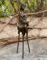 Statue of a girl with apple on bar chair made of bronze