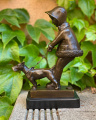 Bronze statue of a girl walking the dog