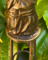 Statue of a woman doing makeup on chair made of bronze