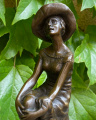 Statue of a woman with a hat on chair made of bronze