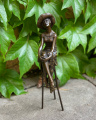 Statue of a woman with a hat on chair made of bronze